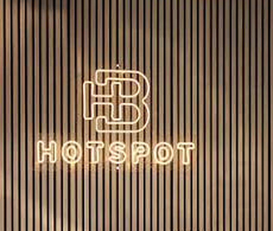 Het neonlogo op de lamellenwand — Hotspot Barbershop